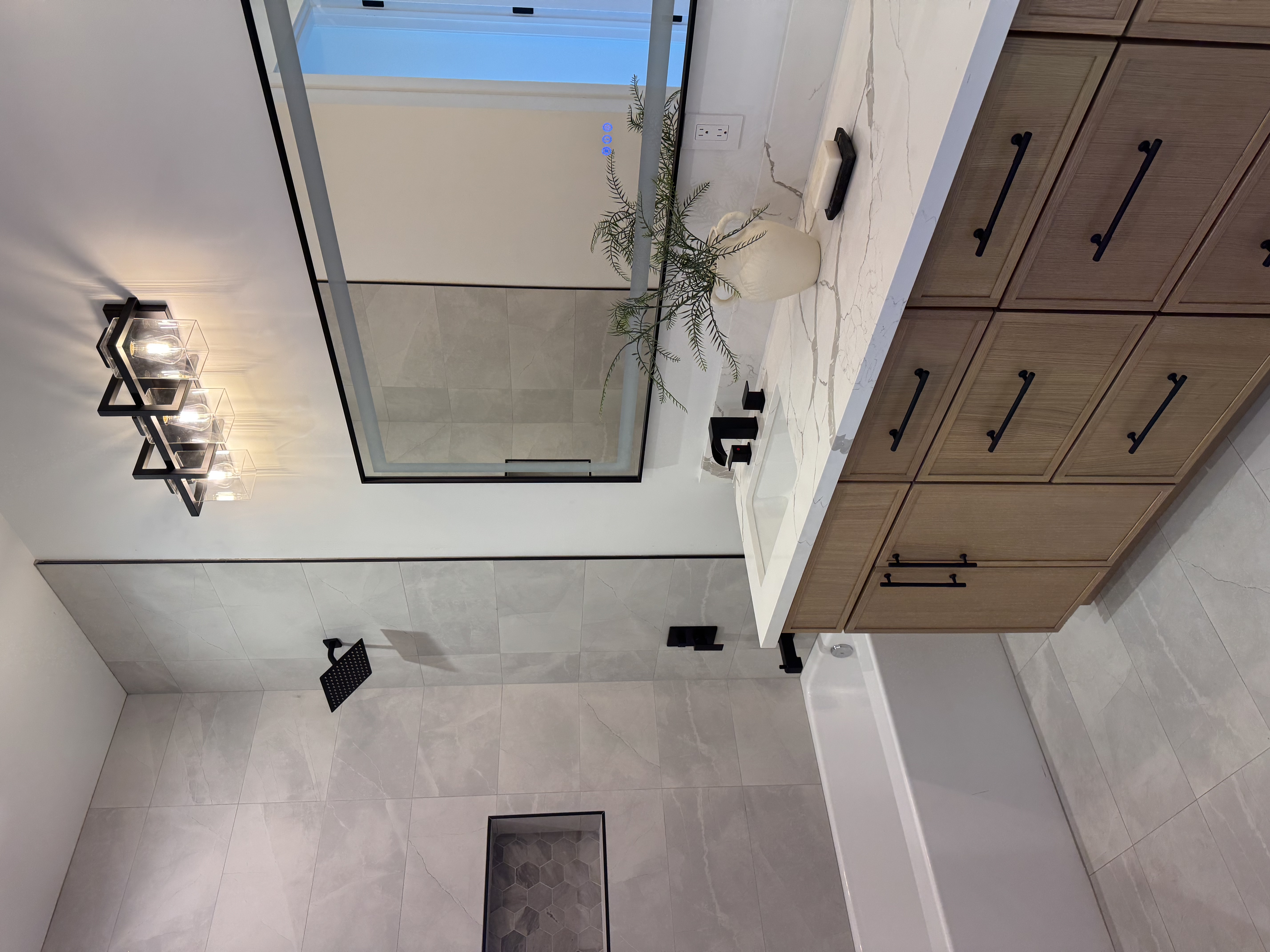 Natural-finish bathroom remodel in Gilbert AZ with warm tile, frameless glass, and spa-inspired fixtures