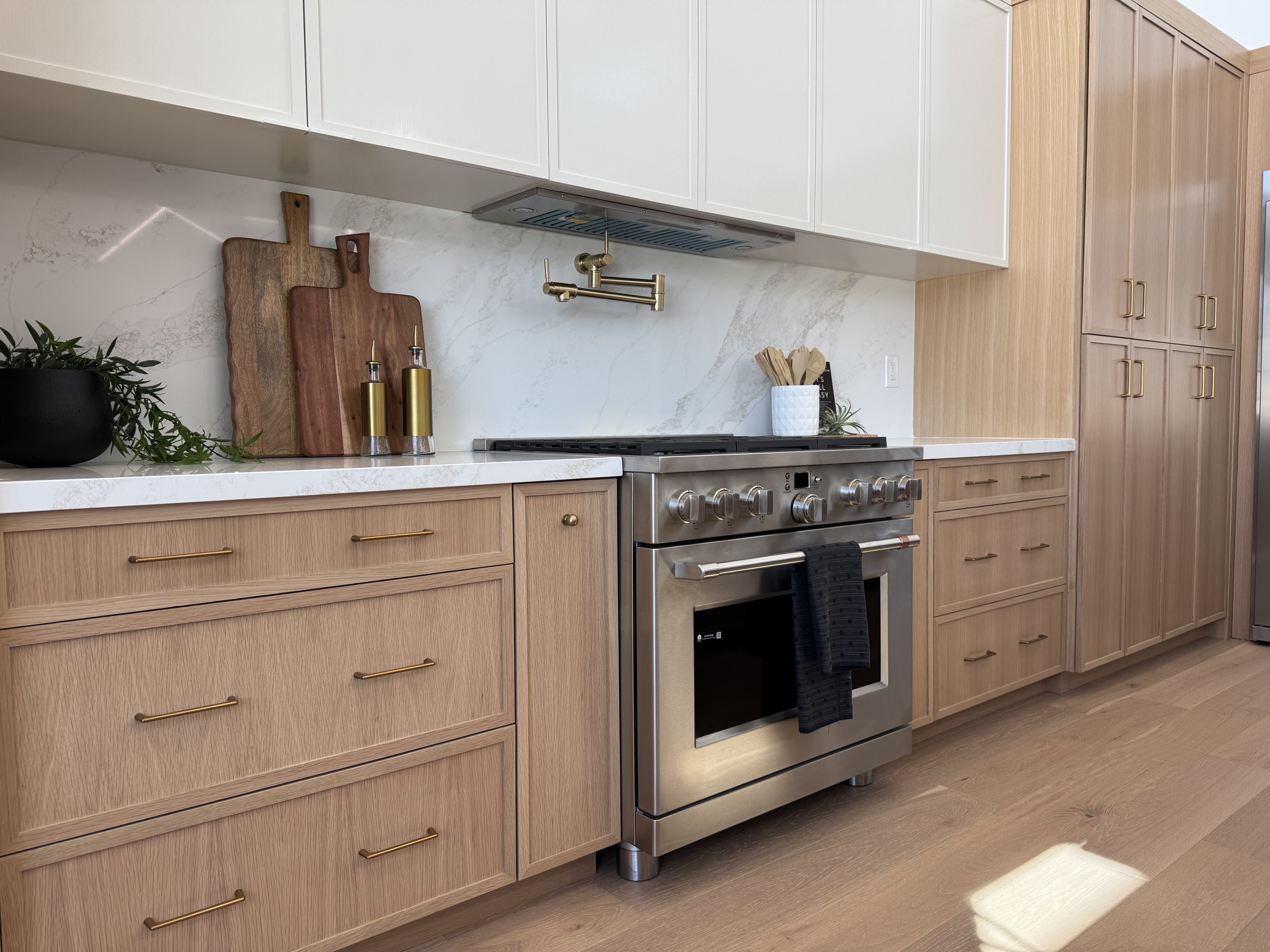 Warm natural kitchen remodel in Scottsdale AZ with wood-tone cabinetry, stone countertops, and clean modern lines